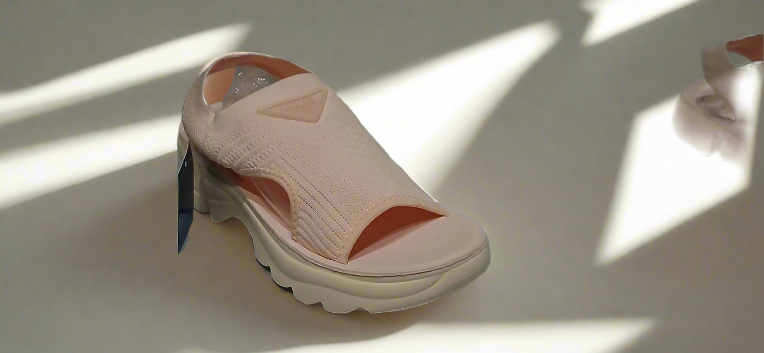 Pink sandal with a tag on a gray surface