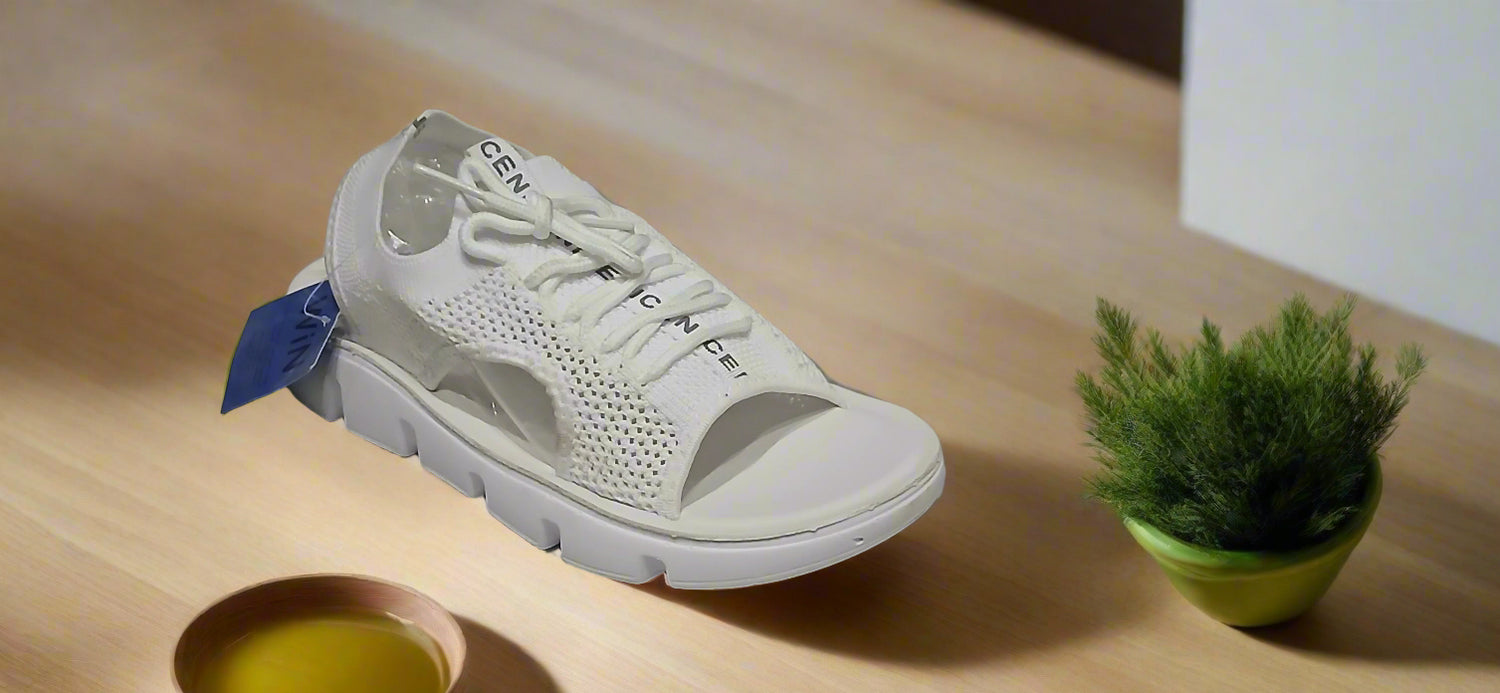 White athletic shoe with brand name on a gray surface